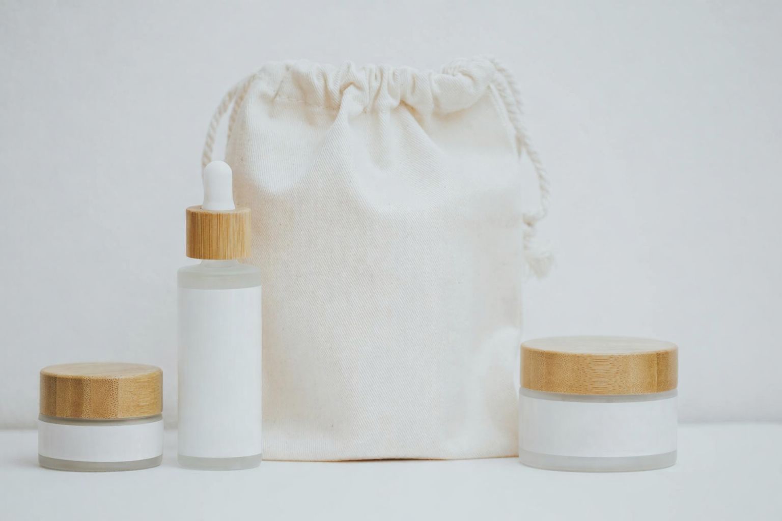 Hudvårdsprodukter med bambulock och tygpåse, hållbara profilprodukter.